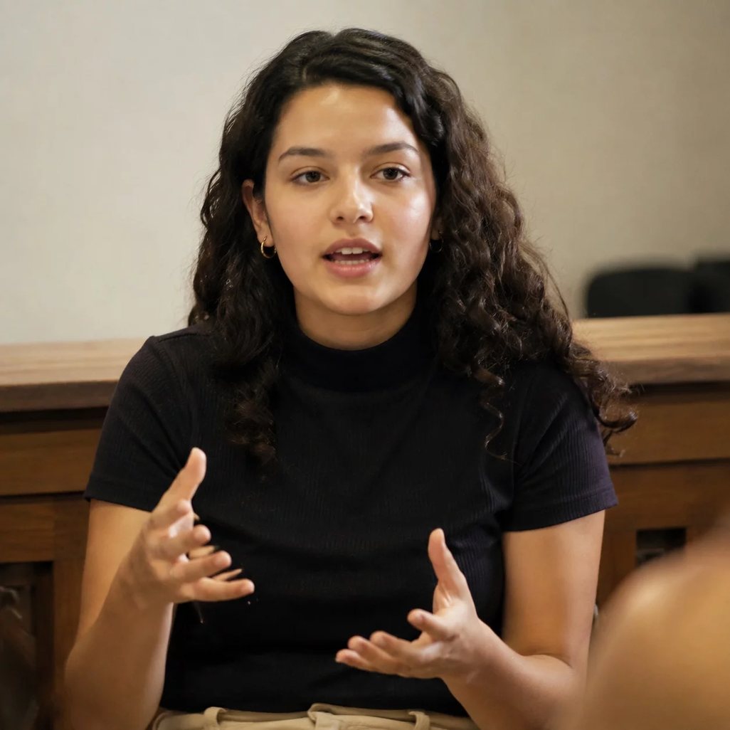 Microfone sobre a tribuna, com a plateia sentada fora de foco ao fundo