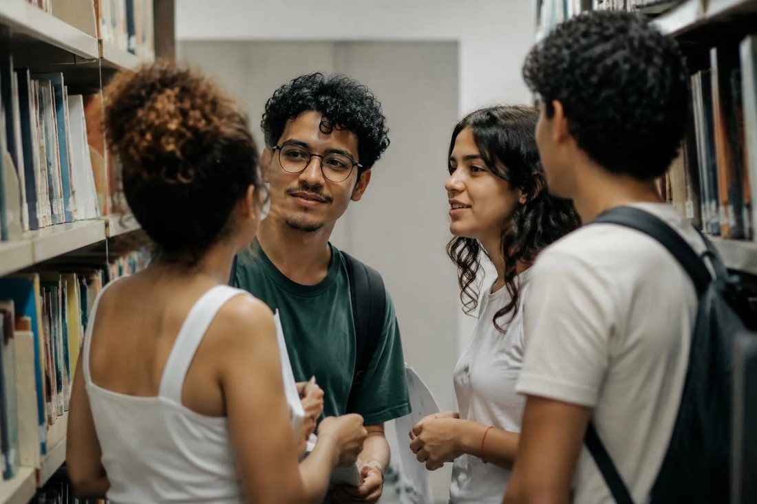 Estudantes de mochila conversando no corredor de uma universidade